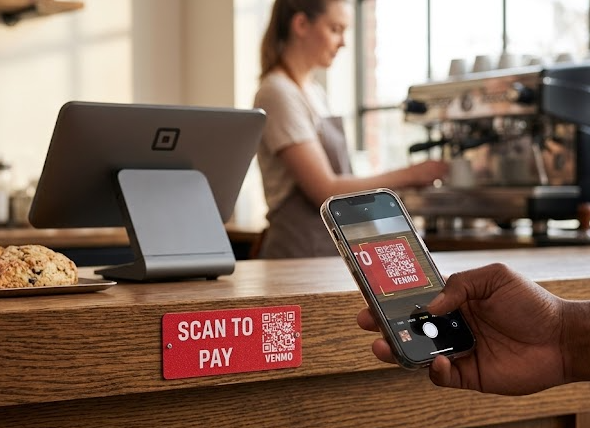 Scan to Pay sign mounted on a coffee shop checkout counter, customer scanning the QR code